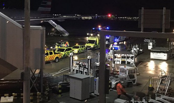 Xe của các đơn vị cấp cứu đậu cạnh một máy bay American Airlines có hành khách bị bệnh lạ - Ảnh: mirror.co.uk