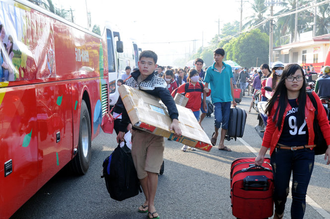 Công nhân mang hành lý ra xe về quê đón tết cùng gia đình - Ảnh: A Lộc