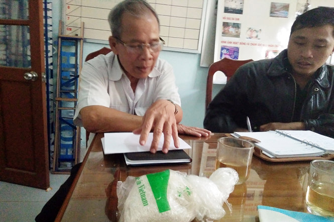 Ông Trần Văn Thắng-chủ tịch Hội nạn nhân chất độc da cam huyện Hiệp Đức trao đổi vụ việc - Ảnh: LÊ TRUNG