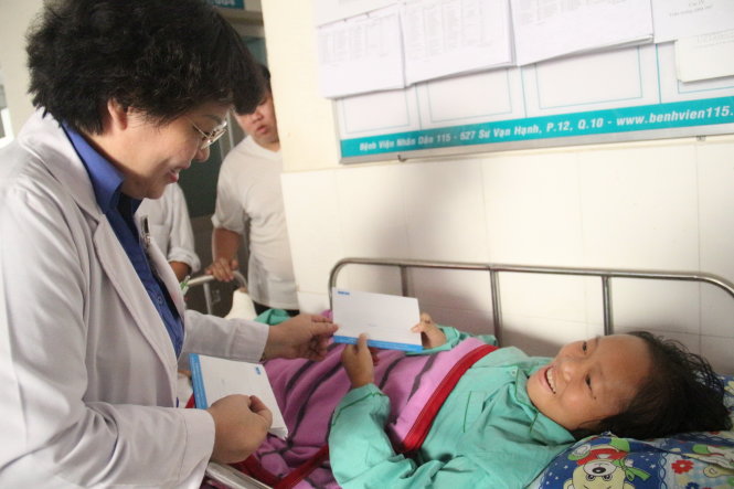 Bà Trần Thị Tố Nga đang điều trị tại  Bệnh viện 115 (TP.HCM) nhận quà của chương trình “Xuân yêu thương…” - Ảnh: M.Phượng