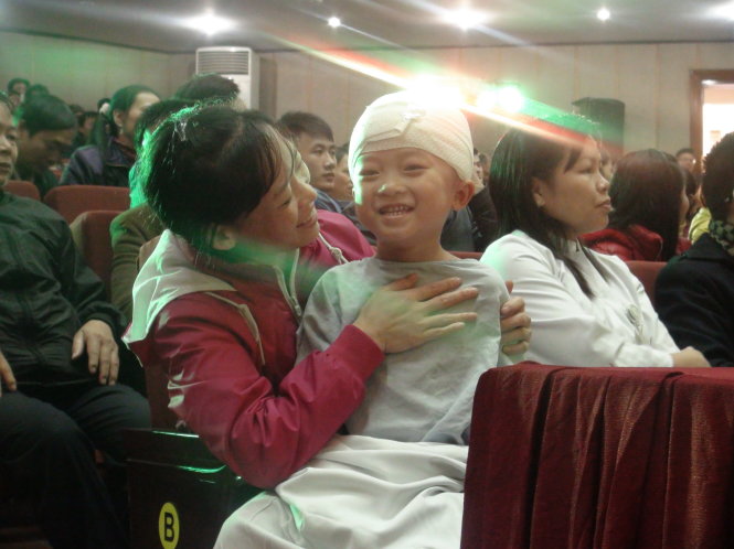 Chị Trần Thị Biên và con trai Dương Thành Trung  theo dõi các tiết mục biểu diễn của chương trình
 - Ảnh: Dương Liễu