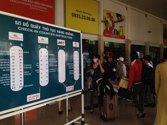 Bảng hướng dẫn các quầy làm thủ tục đặt phía trước lối vào sân bay Tân Sơn Nhất - Ảnh: Lê Sơn