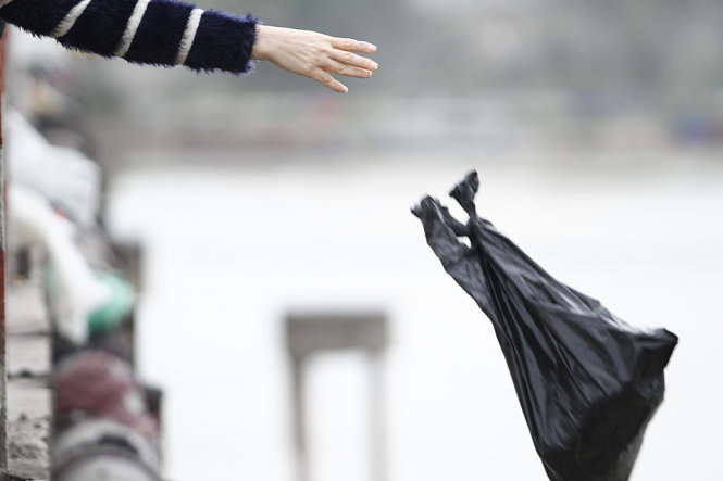 Một túi rác to bị ném từ trên cầu Chương Dương - Ảnh: Nam Trần