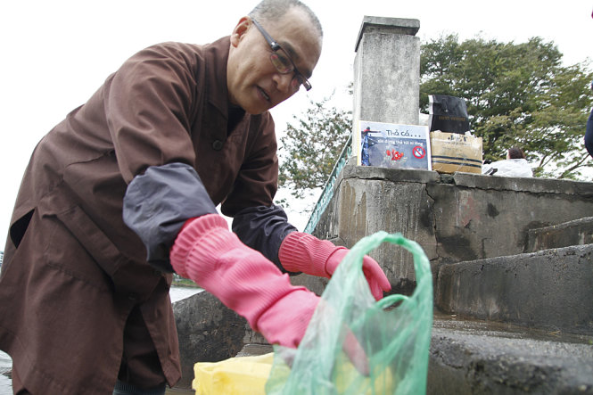 Thầy Thích Tịnh Giác - chùa Phúc Sơn, Long Biên, Hà Nội vận động người dân thả cá đừng xả rác để bảo vệ môi trường - Ảnh: Nam Trần