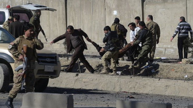 An ninh Afghanistan di chuyển một nạn nhân của vụ đánh bom tự sát Ảnh: AFP