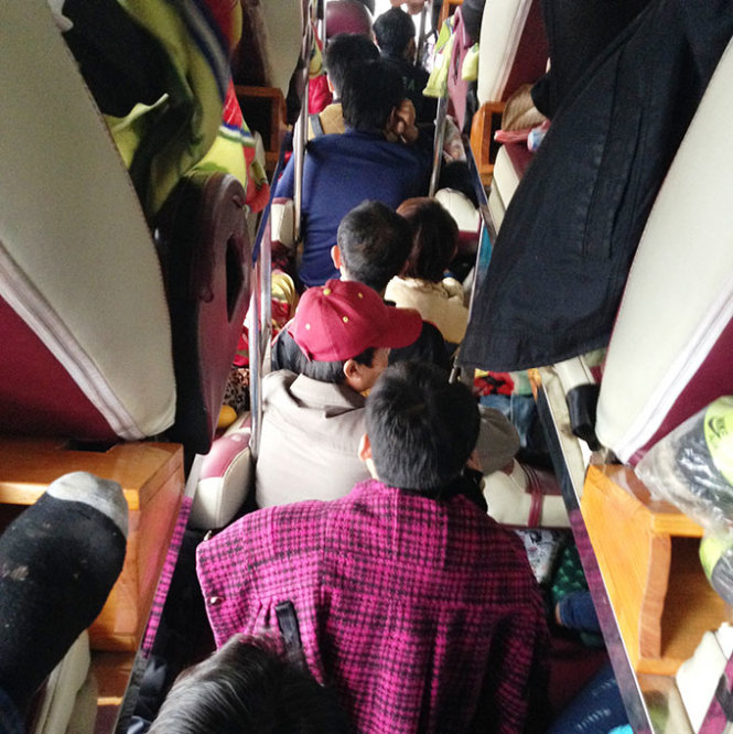 Hành khách trên xe UN-45... từ Lào về, bị nhồi nhét phải ngồi trên lối đi  - Ảnh: Doãn Hòa