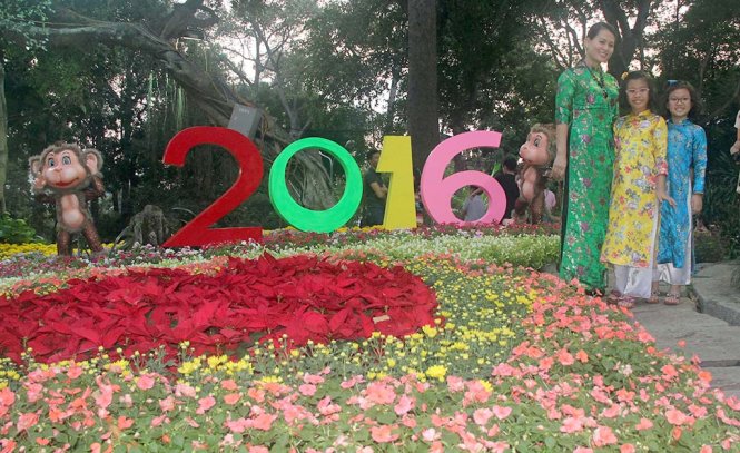 Nhiều du khách thích thú chụp ảnh tại khu vực trang trí hoa và linh vật khỉ bên trong Hội hoa xuân 2016 - Ảnh: Quang Khải