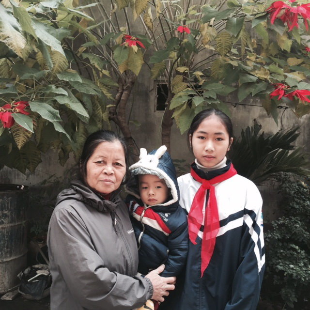 Bà Bình, bé Thương và cháu trai hơn 2 tuổi bà đang trông thuê - Ảnh: L.Anh