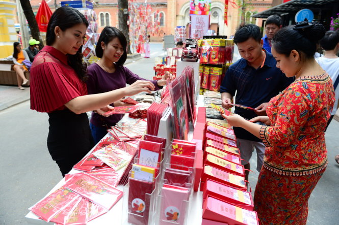 Khách chọn mua thiệp chúc xuân, câu đối chúc tết tại phiên chợ xuân ở đường sách Nguyễn Văn Bình, TP.HCM chiều 3-2 - Ảnh: Quang Định