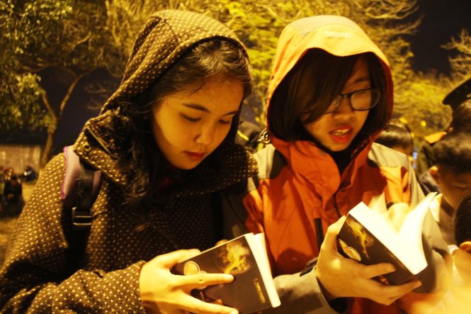 Hai bạn trẻ chăm chú đọc ngay sau khi nhận được sách từ chương trình - Ảnh: PHAN THÀNH