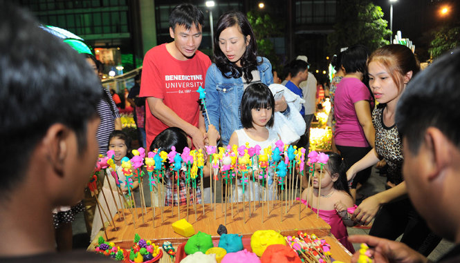 Nhiều em nhỏ thích thú với các con tò he ở đường hoa xuan Nguyễn Huệ - Ảnh: Tự Trung
