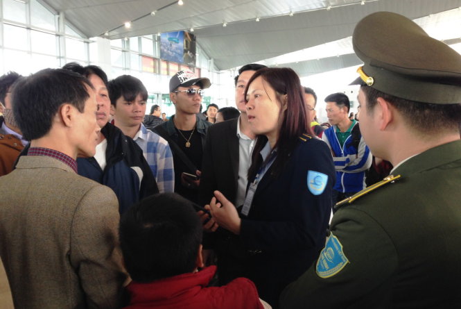 Bà Nguyễn Thị Phương Lan, chuyên viên Cảng vụ hàng không miền Bắc tại sân bay Vinh, giải thích cho các hành khách việc hoãn chuyến bay Ảnh: D.HÒA