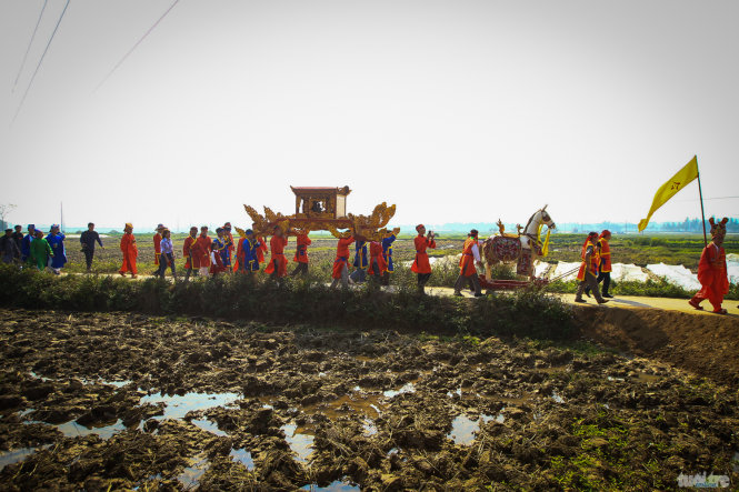 Đoàn rước đi qua cánh đồng làng với mong ước cả làng sẽ có một vụ mùa bội thu - Ảnh: Nguyễn Khánh