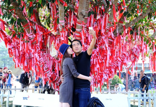 Chụp hình lưu niệm bên cây tình yêu - Ảnh: Lâm Thiên