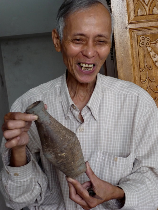 Nhà nghiên cứu Hồ Tấn Phan đang thuyết minh về một món đồ gốm trục vớt dưới đáy sông Hương - Ảnh: Minh Tự

