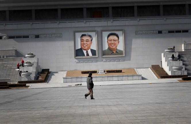 Một người dân đi qua khu quảng trường Kim Nhật Thành có hình ảnh chân dung của hai nhà lãnh đạo quá cố của CHDCND Triều Tiên là Kim Nhật Thành và Kim Jong Il - Ảnh: AP