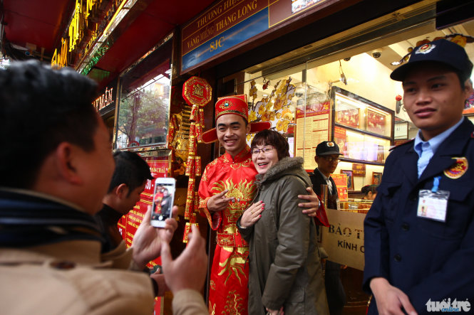 Trong lúc chờ xếp hàng một khách hàng tranh thủ chụp ảnh với “ông thần tài” tại một cửa hàng vàng