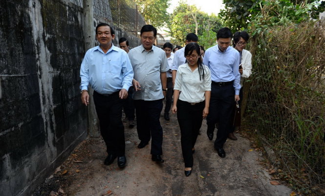 Bí thư Đinh La Thăng trên con đường vào nhà mẹ Nguyễn Thị Em và chỉ đạo phải làm đường mới tốt hơn - Ảnh: Thuận Thắng