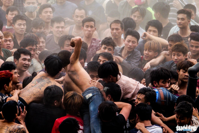 Một người đàn ông vung nắm đấm vào đám đông trong khi tranh giành phết - Ảnh: Nguyễn Khánh