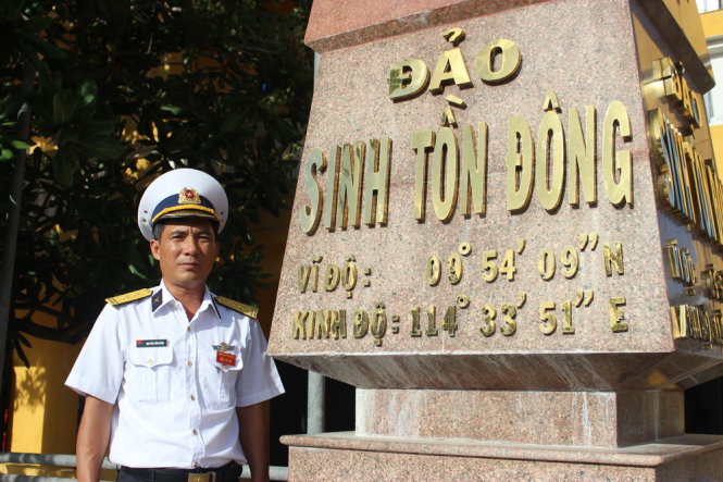 Trung tá Nguyễn Văn Bình - chỉ huy trưởng đảo Sinh Tồn Đông, Trường Sa - bên mốc chủ quyền ở đảo và những chú bồ câu ở đảo Sinh Tồn Đông (ảnh nhỏ) - Ảnh: Hà Bình