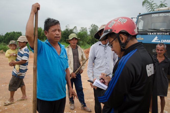 Người dân cầm cuốc kéo ra chặn xe thi công sáng 20-2 - Ảnh: Tấn Lực