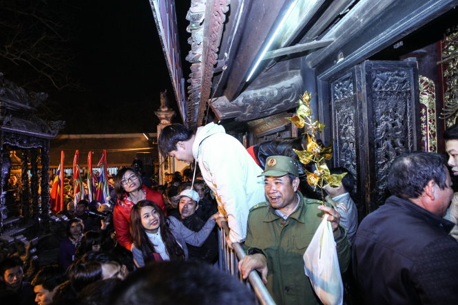 Một người đàn ông tươi cười khi lấy được cho mình một cành lộc từ trong điện thờ - Ảnh: Nguyễn Khánh