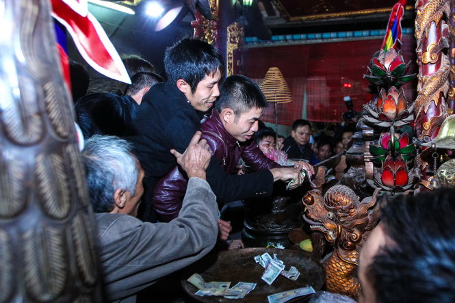 Nhiều người nhảy lên bàn thờ để đặt lễ - Ảnh: Nguyễn Khánh