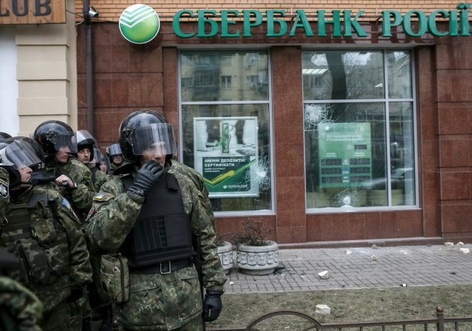 An ninh Ukraine bảo vệ chi nhánh ngân hàng Sberbank ở thủ đô Kiev - Ảnh: Reuters