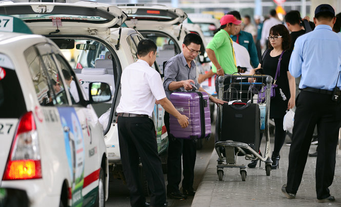 Mặc dù giá xăng dầu đã giảm nhưng giá cước các hãng taxi vẫn chưa giảm. Trong ảnh là người dân đi taxi tại sân bay quốc tế Tân Sơn Nhất, TP.HCM trưa 22-2 - Ảnh: Quang Định