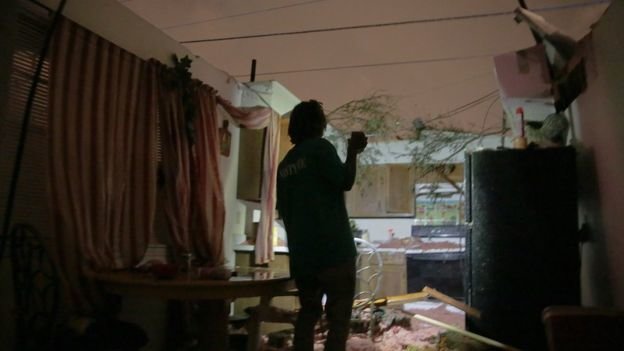 Một người dân ở nam Louisiana đang kiểm tra ngôi nhà mình bị hư hại sau bão - Ảnh: AP
