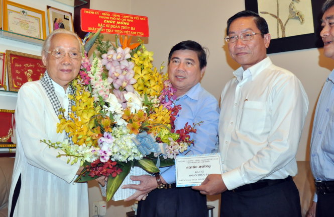 Ông Nguyễn Thành Phong - chủ tịch UBND TP - tặng hoa chúc mừng cho bác sĩ Đoàn Thúy Ba - Ảnh: Q.Khải