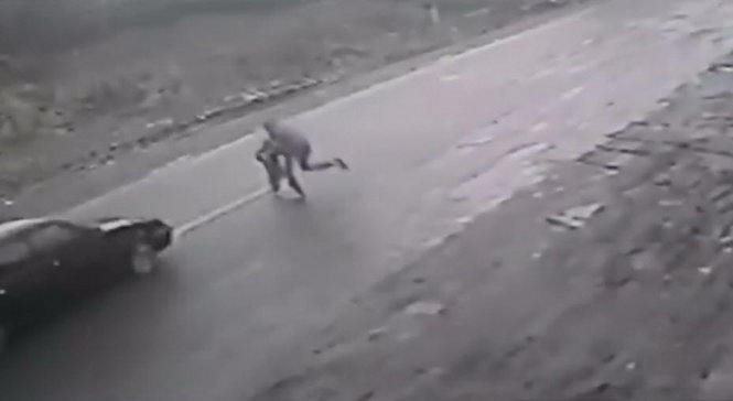 Người đàn ông lao ra đường cứu cậu bé thoát chết trong gang tấc - Ảnh chụp từ video clip