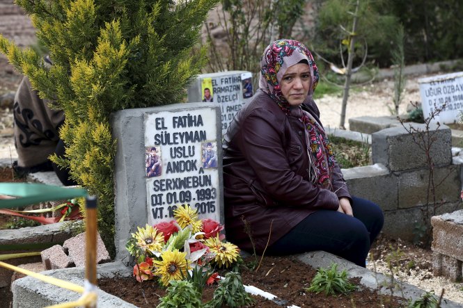 Một phụ nữ ngồi bên mộ con trai thiệt mạng trong cuộc chiến ở miền bắc Syria ngày 25-2 - Ảnh: Reuters