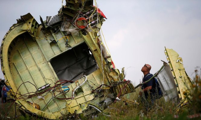 Một nhà điều tra người Malaysia tại hiện trường máy bay MH17 bị bắn rơi gần làng Grabovo ở vùng Donetsk, Ukraine - Ảnh: Reuters