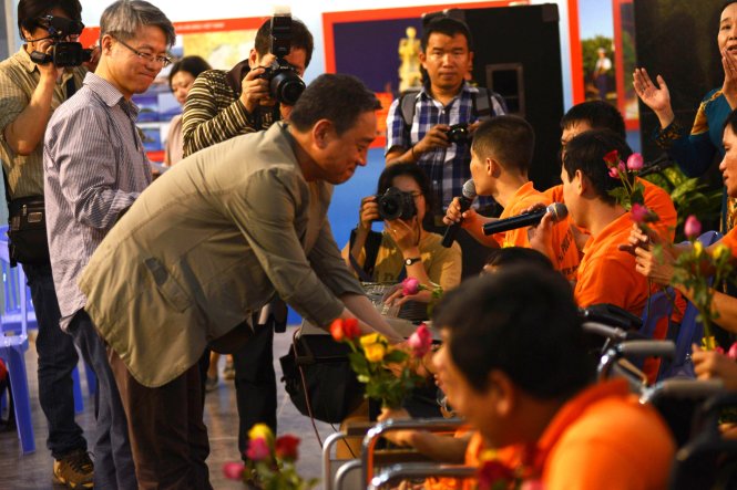 Ông Roh Hwa Wook của Quỹ hòa bình Hàn - Việt tặng hoa cho các nạn nhân chất độc da cam - Ảnh: Duyên Phan
