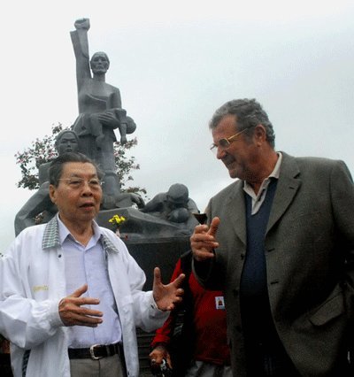 NSƯT - đạo diễn Lê Dân (trái) trò chuyện với ông Saub Gérard trước tượng đài chứng tích Sơn Mỹ ở xã Tịnh Khê, huyện Sơn Tịnh (Quảng Ngãi) - Ảnh tư liệu TT.