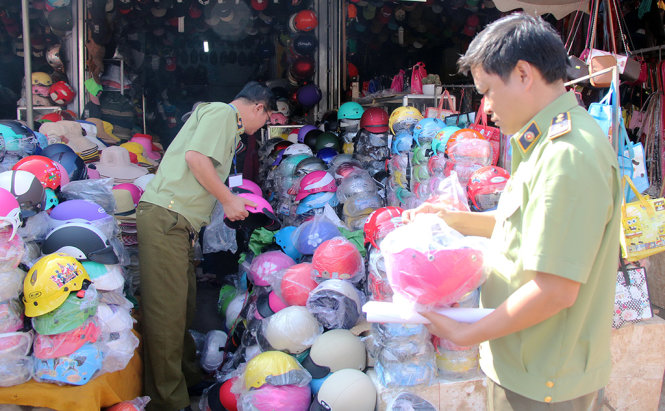 Ông Trần Nguyên Đức (bìa phải) - khi đang là chi cục phó Chi cục Quản lý thị trường tỉnh Đắk lắk trong một vụ bắt mũ bảo hiểm giả, nhái tại thị xã Buôn Hồ tháng 1-2015 - Ảnh: LINH ĐAN