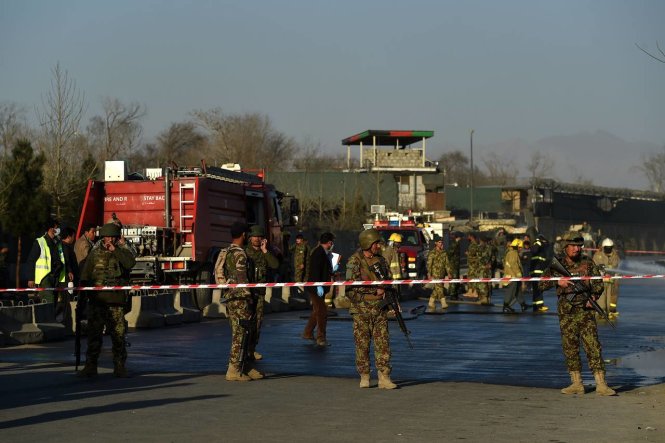 Lực lượng an ninh Afghanistan bảo vệ các lính cứu hỏa tại hiện trường vụ đánh bom tự sát gần cổng Bộ Quốc phòng tại Kabul hôm 27-2 - Ảnh: Wall Street Journal/Getty Images
