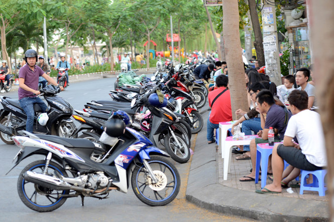 Các hàng ăn vặt sử dụng lòng đường làm chỗ để xe cho khách trên đường Xô Viết Nghệ Tĩnh (Q.Bình Thạnh) - Ảnh: Duyên Phan