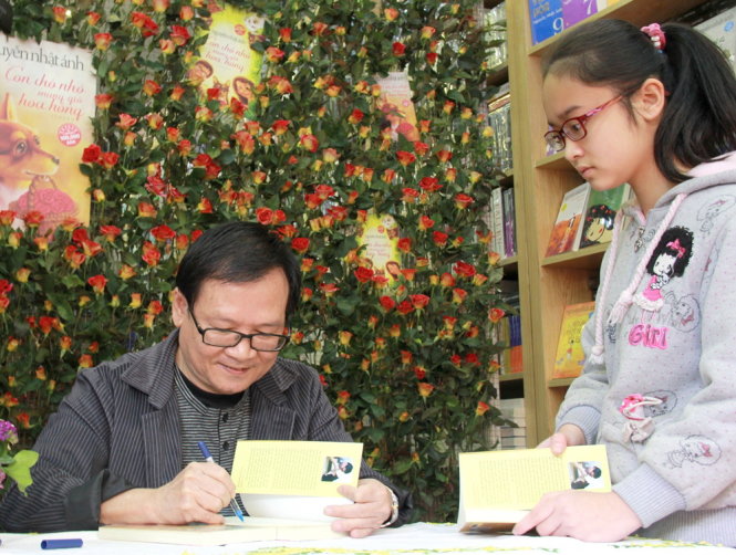 Nguyễn Nhật Ánh ký tặng sách cho độc giả trẻ: Năm nào cũng mệt mà vui - Ảnh: Hạ Huyền