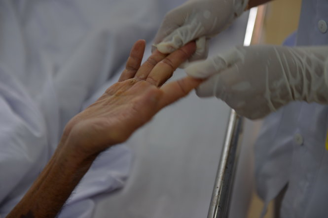 Cái nắm tay nhẹ nhàng của các bác sĩ cũng là niềm động viên tin thần cho bệnh nhân nhiễm HIV - Ảnh: Hữu Khoa