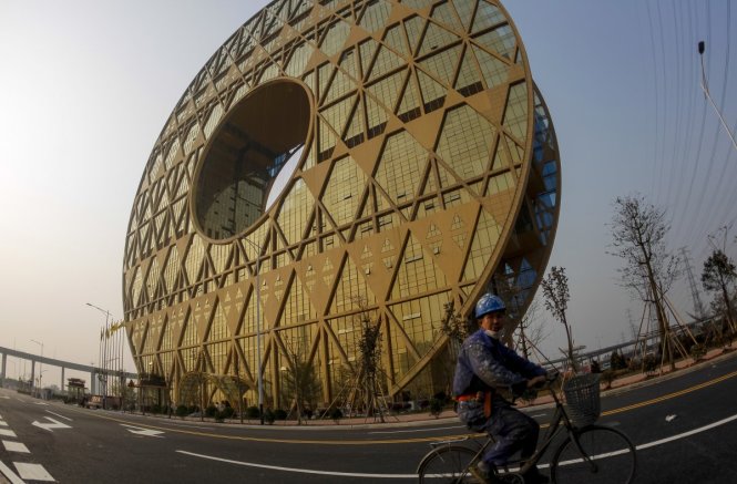 Tòa nhà hình vòng Quảng Châu bên bờ sông Châu Giang được thiết kế nhằm phản chiếu hình ảnh dưới mặt nước tạo ra số 8 may mắn theo cách nghĩ của người Trung Quốc - Ảnh: Reuters