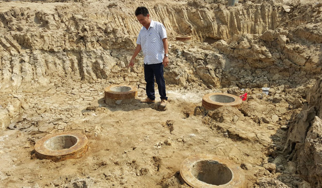 Kỹ sư Mạc Văn Long, đội trưởng đội xây dựng số 5 công ty Trường Phát, ở một trụ móng bị nghiêng - Ảnh: K.Nam