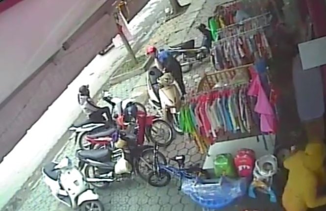 Hình ảnh người phụ nữ móc trộm ví trong xe máy của chị Hiền trong vòng chưa đến 3 giây - Ảnh: D.Hòa cắp từ clip