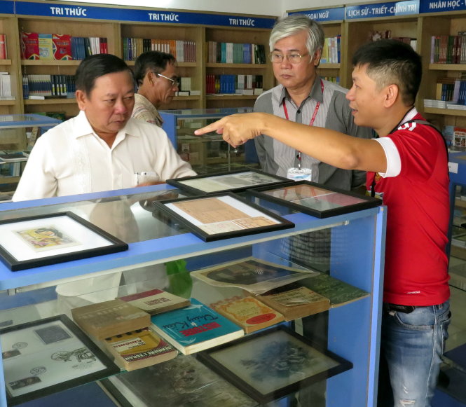 Nhà sưu tập La Văn Tiến (trái) trao đổi với người quan tâm trước phiên đấu giá - Ảnh: L.Điền