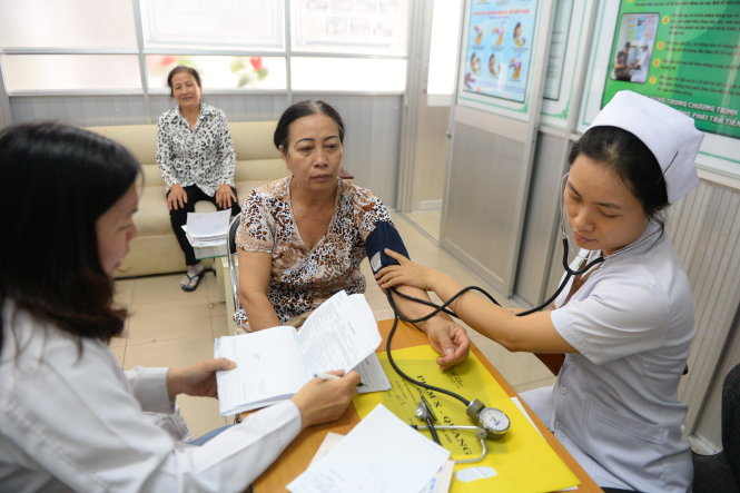 Bác sĩ Phan Chung Thúy Luynh (trái) và điều dưỡng Trần Thanh Thảo Trầm khám cho người dân tại phòng khám y học gia đình Bệnh viện Q.2, TP.HCM - Ảnh: Hữu Khoa