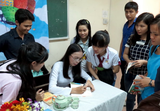  Nhà văn Võ Diệu Thanh tặng chữ ký cho các bạn sinh viên - Ảnh: L.Điền