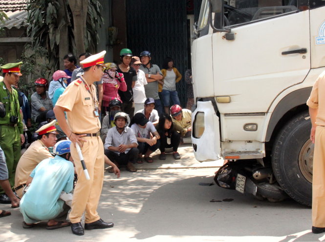 Cơ quan công an khám nghiệm hiện trường vụ tai nạn giao thông giữa xe tải và xe máy - Ảnh: Trần Mai