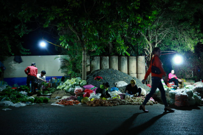 Trong đêm, những người phụ nữ bận rộn buôn bán rau quả trên góc đường Y Moan. Các chị cho biết đã hành nghề buôn bán 10 năm nay và tự nhận mình “không có ngày 8-3”  - Ảnh: Tiến Thành