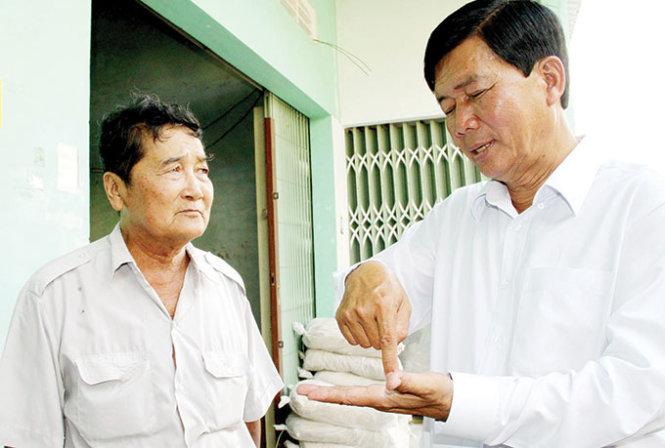 Ông Dương Văn Hùng (phải) hướng dẫn kỹ thuật nuôi tôm “để được trúng lớn” cho nông dân xã Vĩnh Thắng, huyện Gò Quao (Kiên Giang) - Ảnh: Tấn Đức